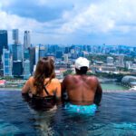 2 people overlooking downtown Singapore from the Marina Bay Sands infinity pool