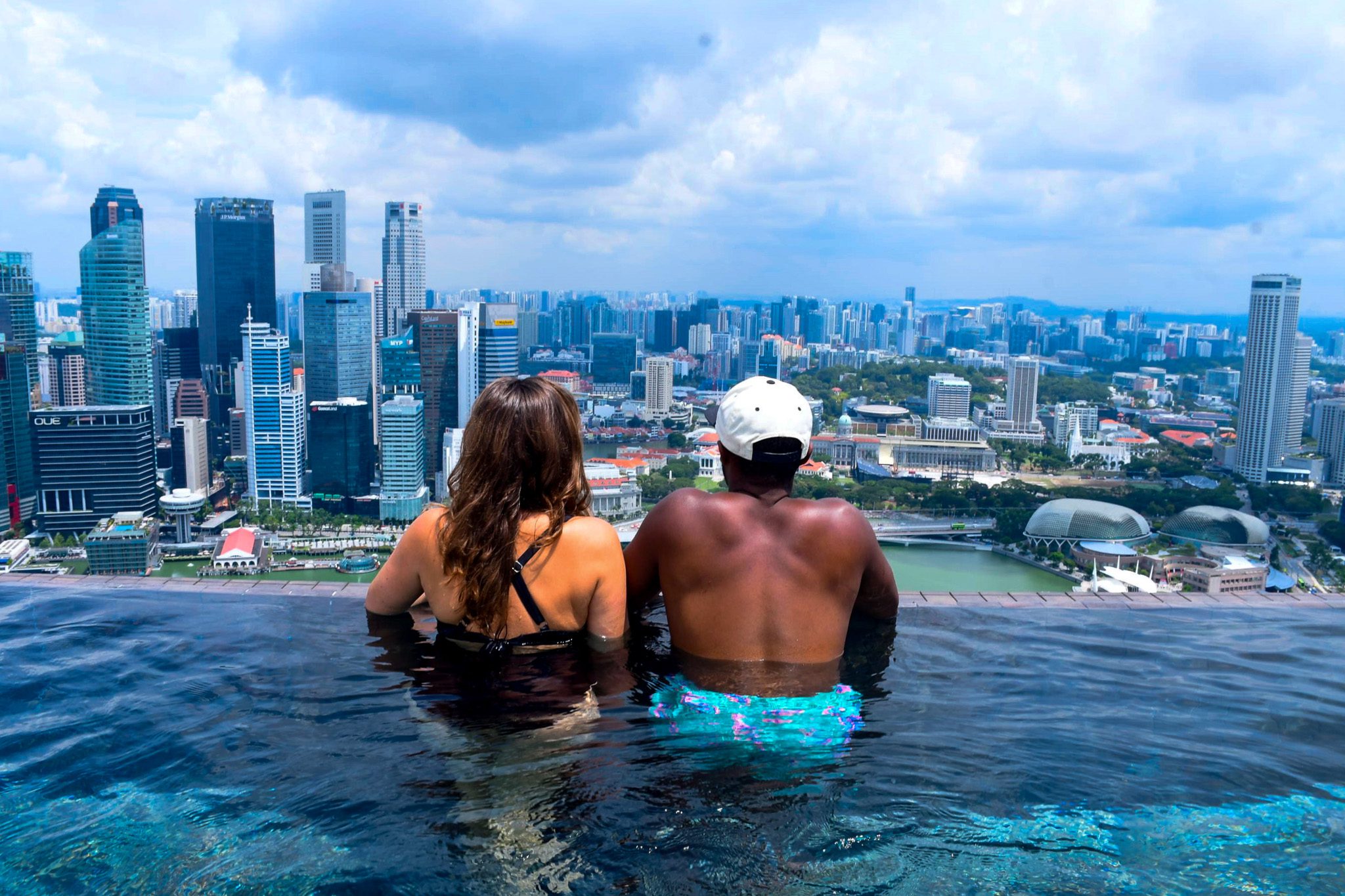 2 people overlooking downtown Singapore from the Marina Bay Sands infinity pool