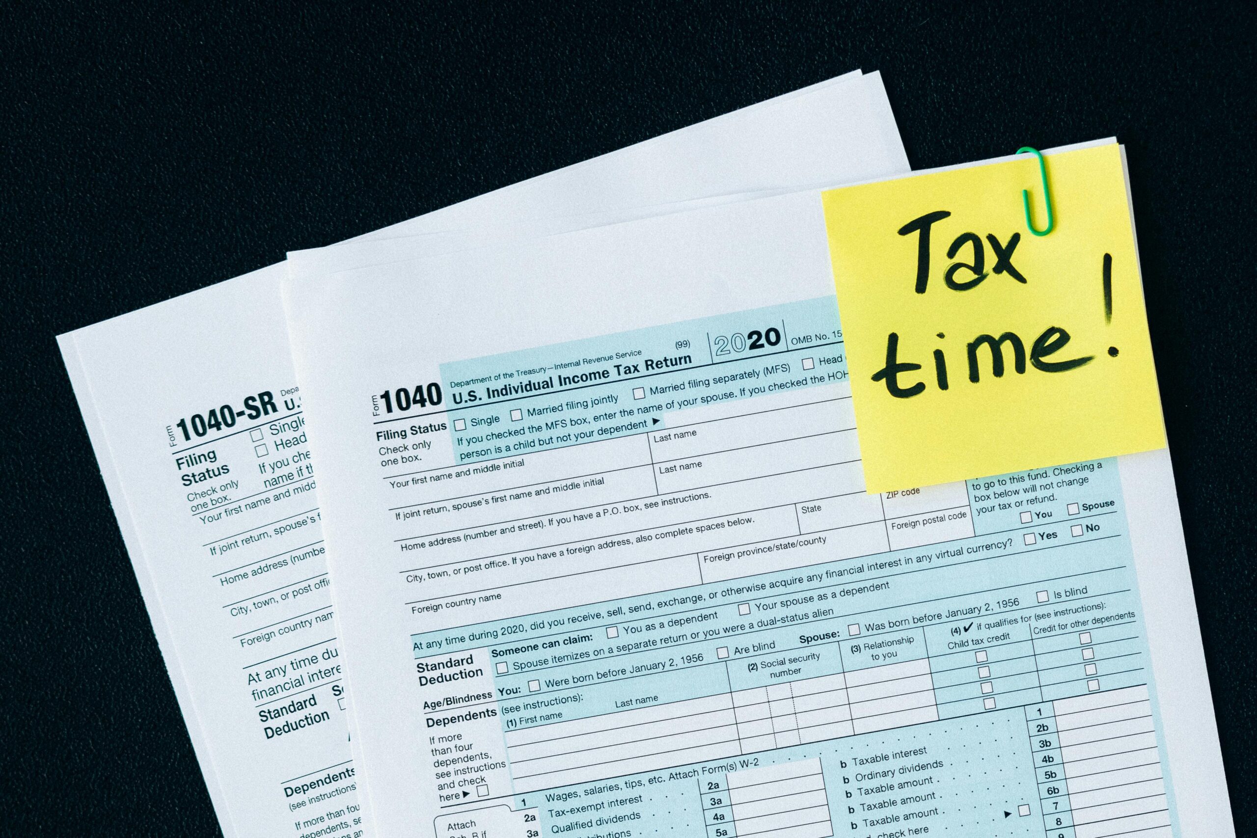 US 1040 Tax form with a post it note that says "Tax Time" attached to it