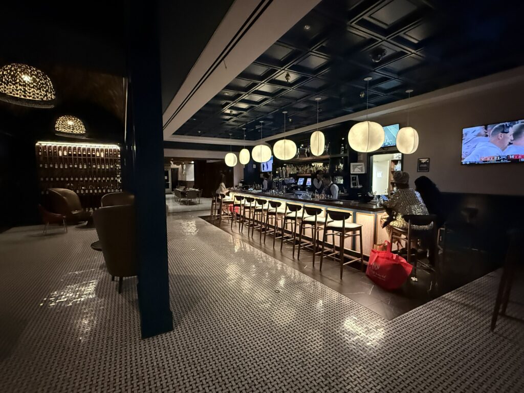 RW Prime bar at Resorts World with modern pendant lighting, bar seating, and a wall of wine bottles.