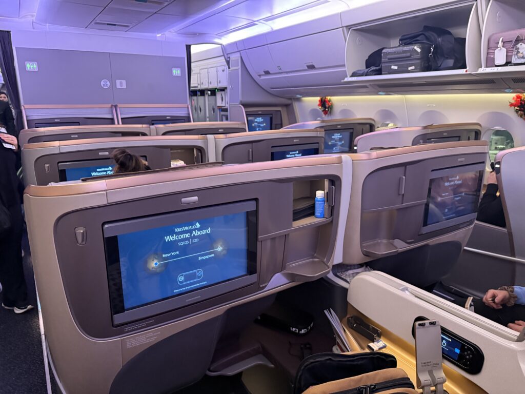 Singapore Airlines Business Class cabin with large KrisWorld entertainment screens and premium seating on the world’s longest flight.