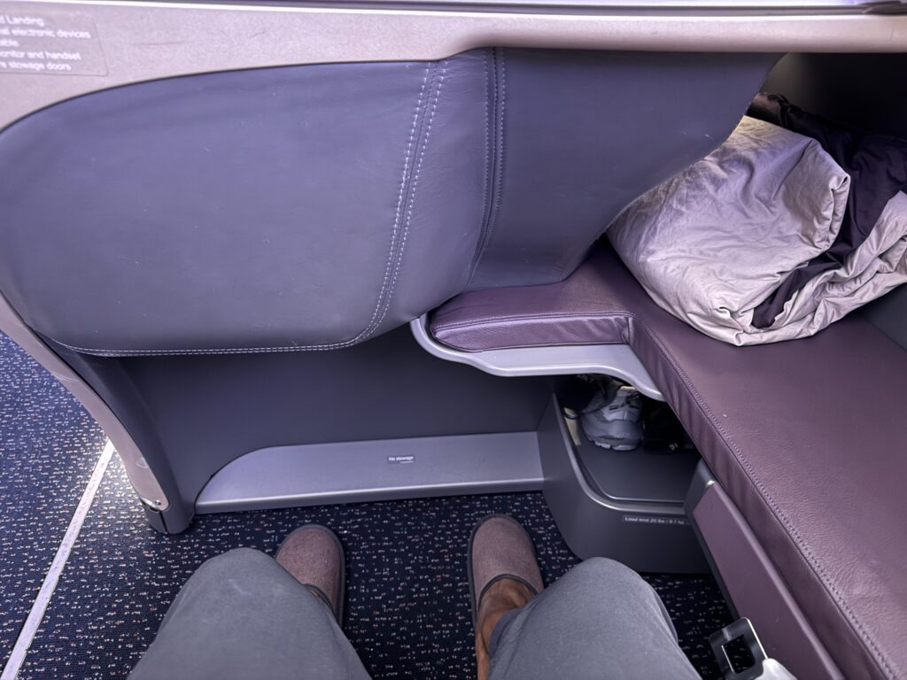 Passenger legroom view in Singapore Airlines Business Class showing narrow footwell design on the Airbus A350.