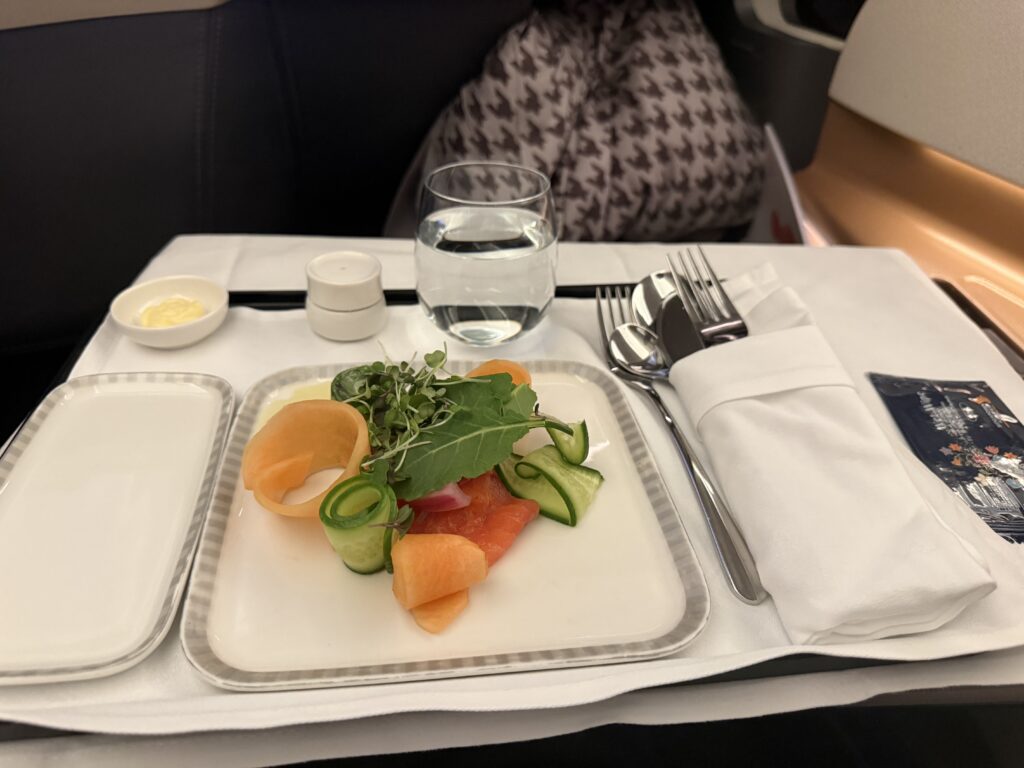Singapore Airlines Business Class appetizer with plated vegetables, microgreens, and creamy dressing served before main meal.