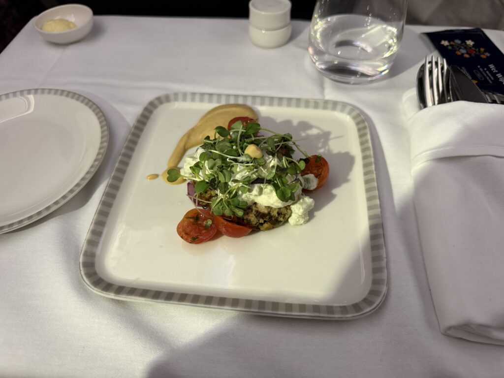 Singapore Airlines Business Class appetizer with plated vegetables, microgreens, and creamy dressing served before main meal.