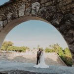 Wedding Couple under a stone arch with at the top of a stone amphitheater