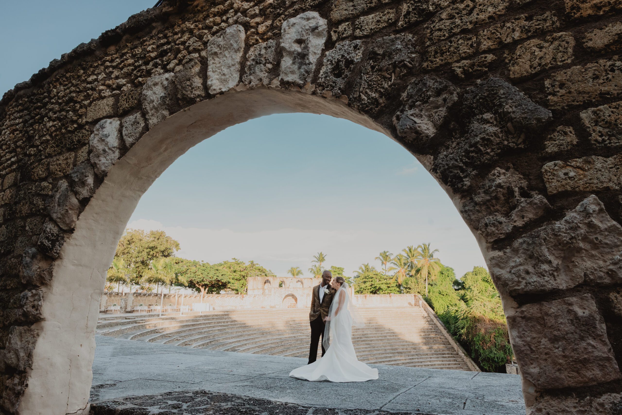 Wedding Couple under a stone arch with at the top of a stone amphitheater