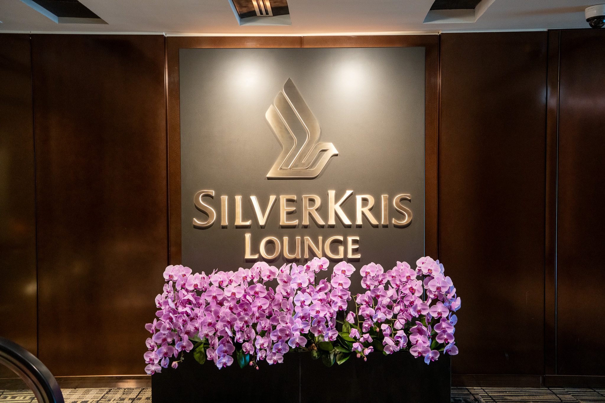 SilverKris Lounge entrance sign with orchids at Singapore Changi Airport.