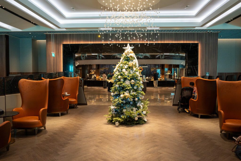 Central area of the Singapore Airlines SilverKris Lounge at Changi Airport decorated for the holidays with seating and buffet access.