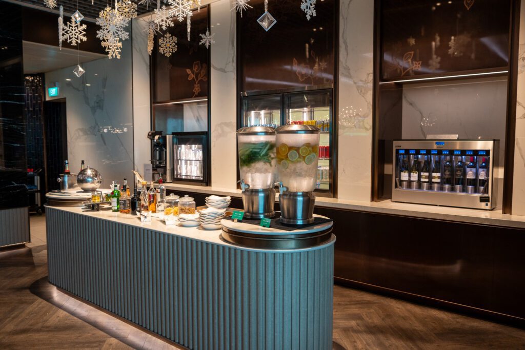 Self-serve beverage station inside the Singapore Airlines SilverKris Lounge at Changi Airport with infused water and wine dispensers.