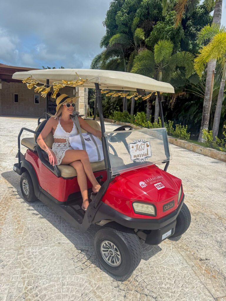 Woman riding a golf cart at Casa de Campo with a just married sign, showing how guests get around the expansive resort