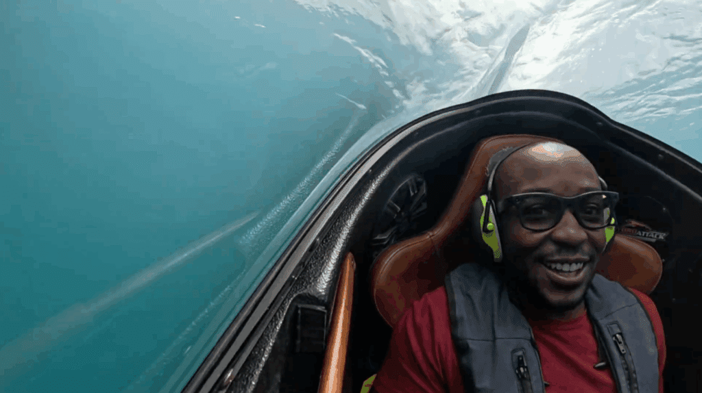 Passenger smiling inside the Hydro Attack cockpit during a high-speed ride on Lake Wakatipu