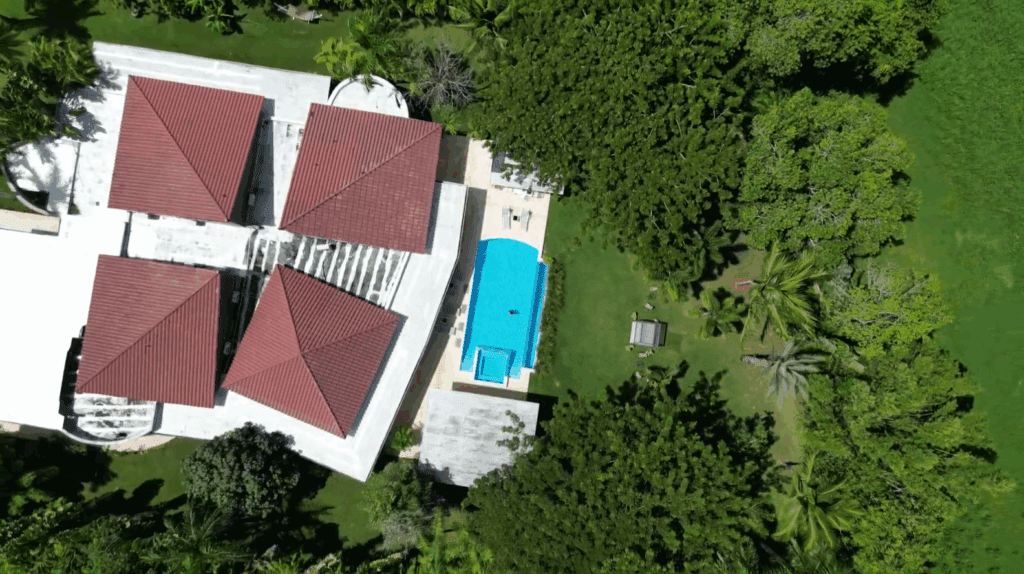 Aerial drone view of a private villa at Casa de Campo with a swimming pool surrounded by tropical greenery in the Dominican Republic