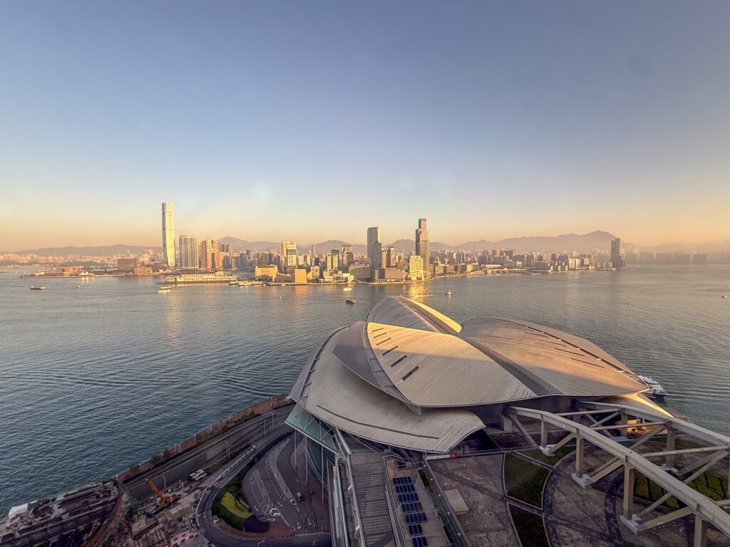Wide view of Victoria Harbour and the Hong Kong skyline at sunset, overlooking the Hong Kong Convention and Exhibition Centre from the Grand Hyatt Hong Kong