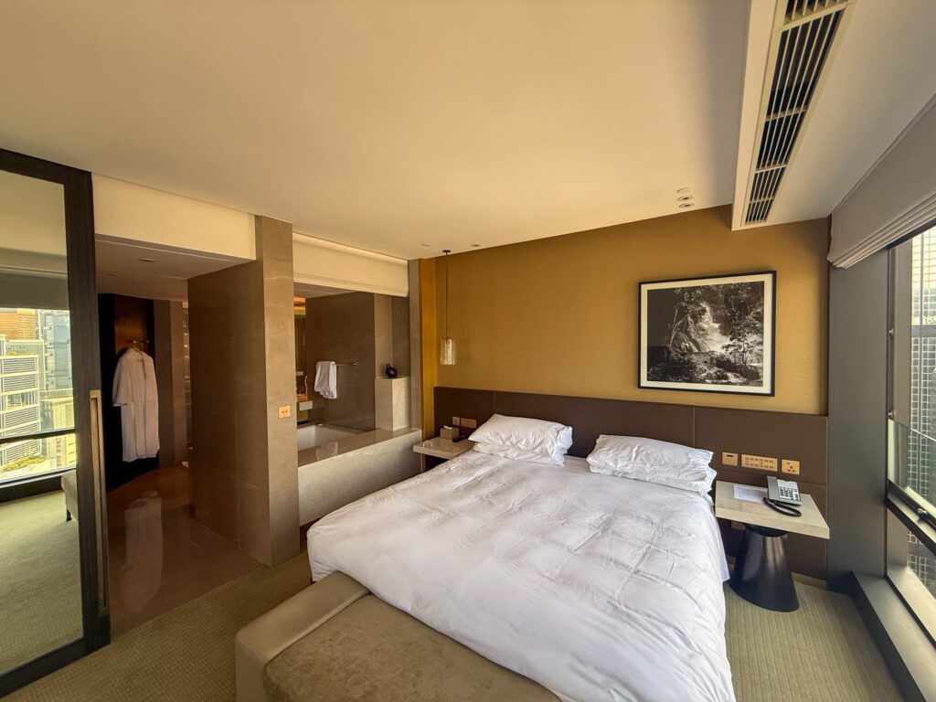 Spacious bedroom and open bathroom layout inside a Victoria Harbour Executive Suite at the Grand Hyatt Hong Kong