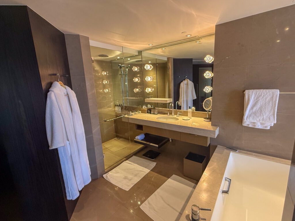 Modern bathroom with walk-in shower, vanity, and soaking tub inside a Victoria Harbour Executive Suite at the Grand Hyatt Hong Kong