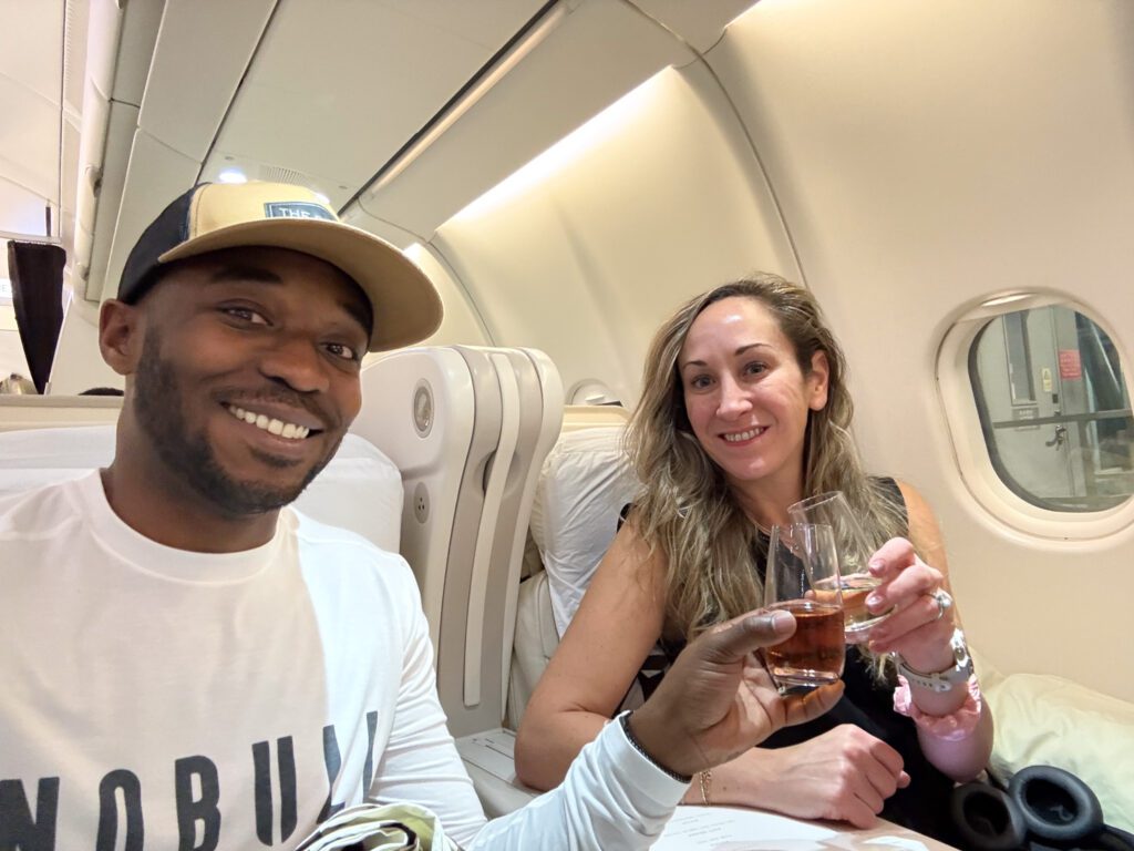 Couple enjoying drinks in Fiji Airways A330 business class cabin during Hong Kong to Nadi flight.