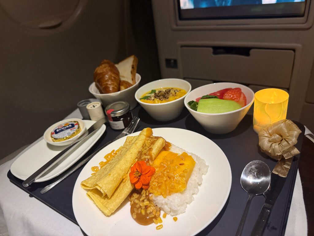 Fiji Airways A330 business class mango crepes with sticky coconut rice and crispy mung beans served with fresh fruit and pastries.