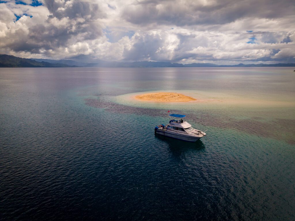 Boat anchored beside a secluded sandbank in Fiji during a private excursion arranged by Namale Resort & Spa.