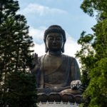Tian Tan Buddha statue on Lantau Island surrounded by trees in Hong Kong