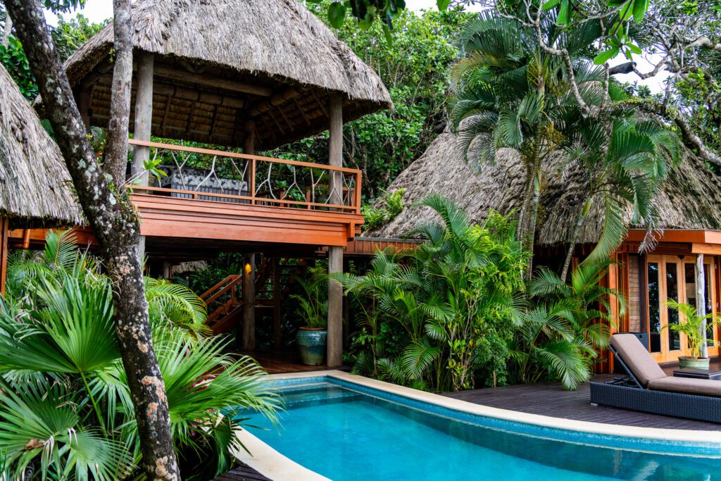 Traditional Fijian-style thatched roof villa surrounded by tropical plants at Namale Resort & Spa.