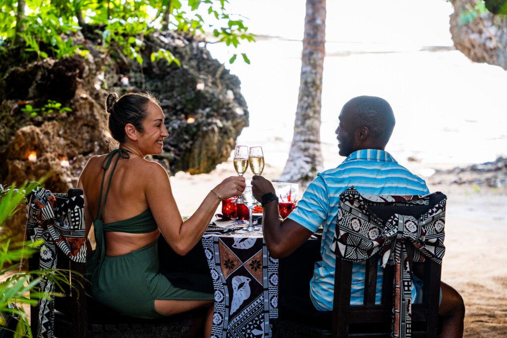 Couple toasting champagne during a private beach dinner at Namale Resort & Spa in Fiji.