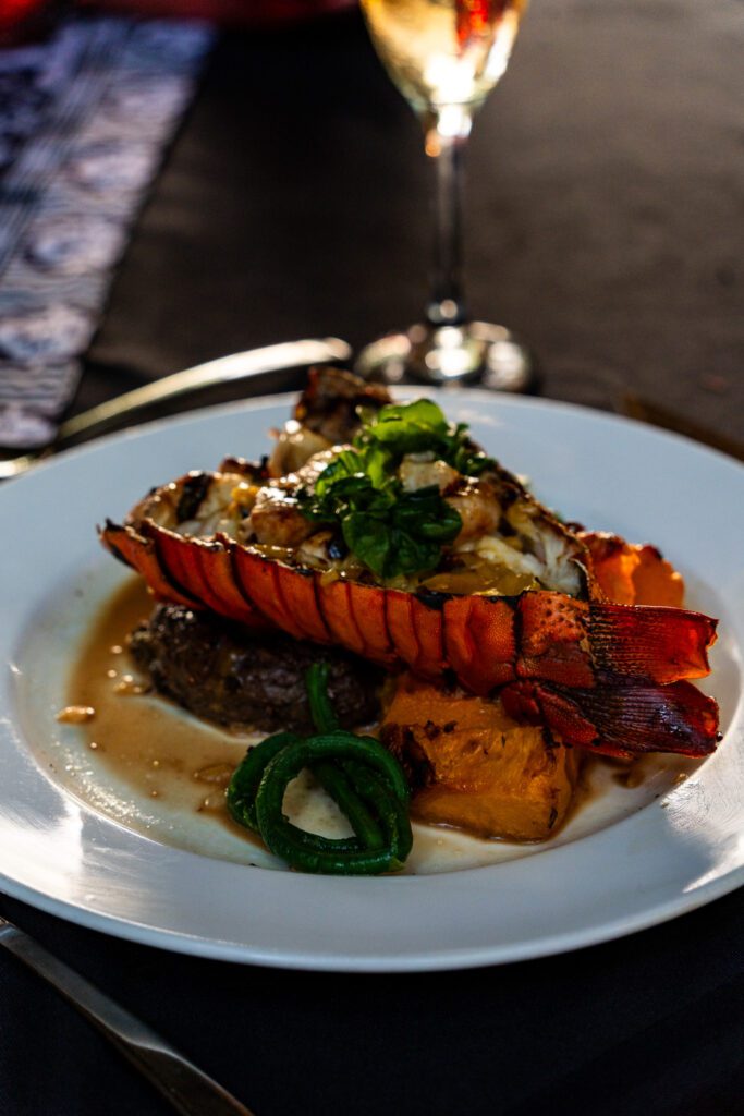 Lobster tail served over steak with fresh vegetables at Namale Resort & Spa, an adults-only all-inclusive in Fiji.