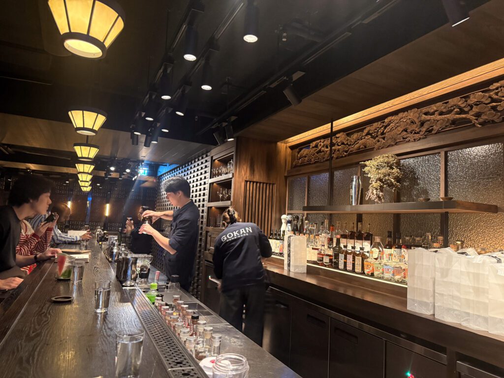 Interior of Gokan cocktail bar in Central Hong Kong with bartenders preparing drinks behind the bar