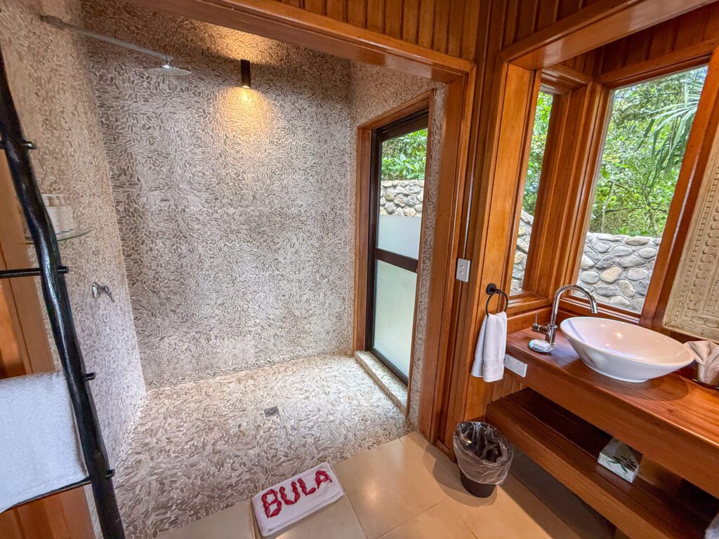 Spacious walk-in shower with stone tile walls inside a private villa at Namale Resort in Fiji.