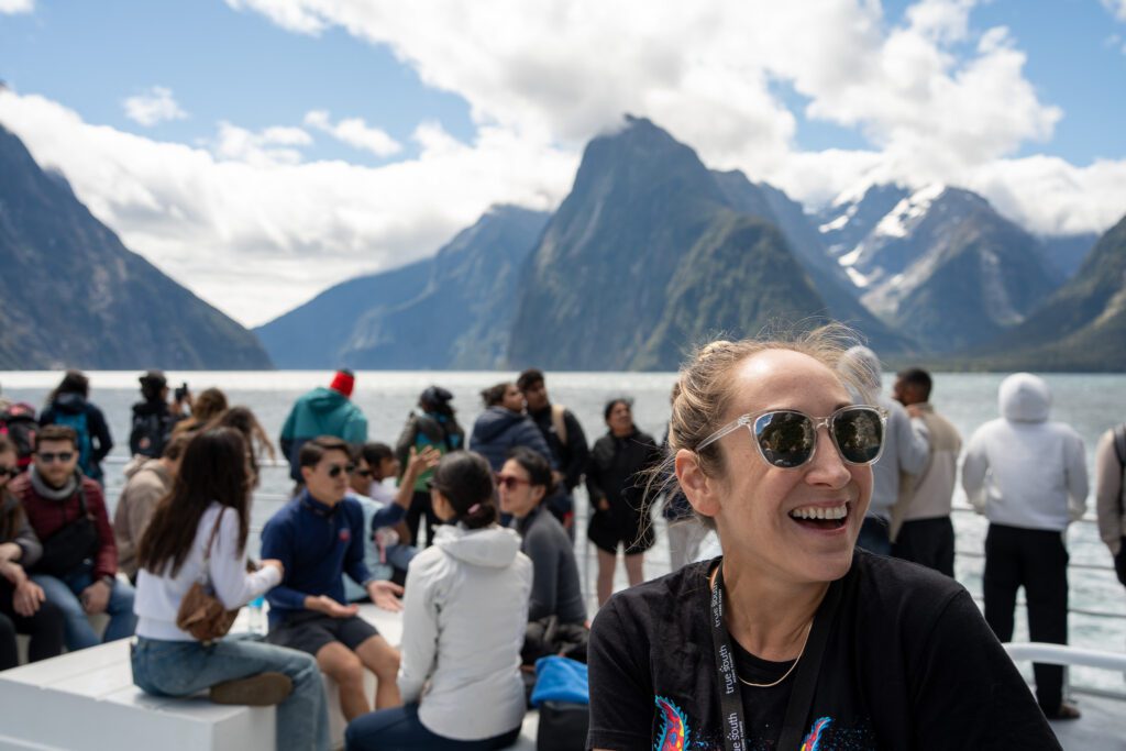 Passengers enjoying views on the upper deck of a Milford Sound cruise boat