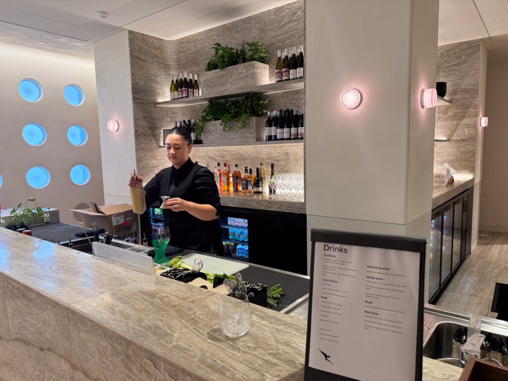Bartender preparing drinks at Qantas Auckland Business Class Lounge bar