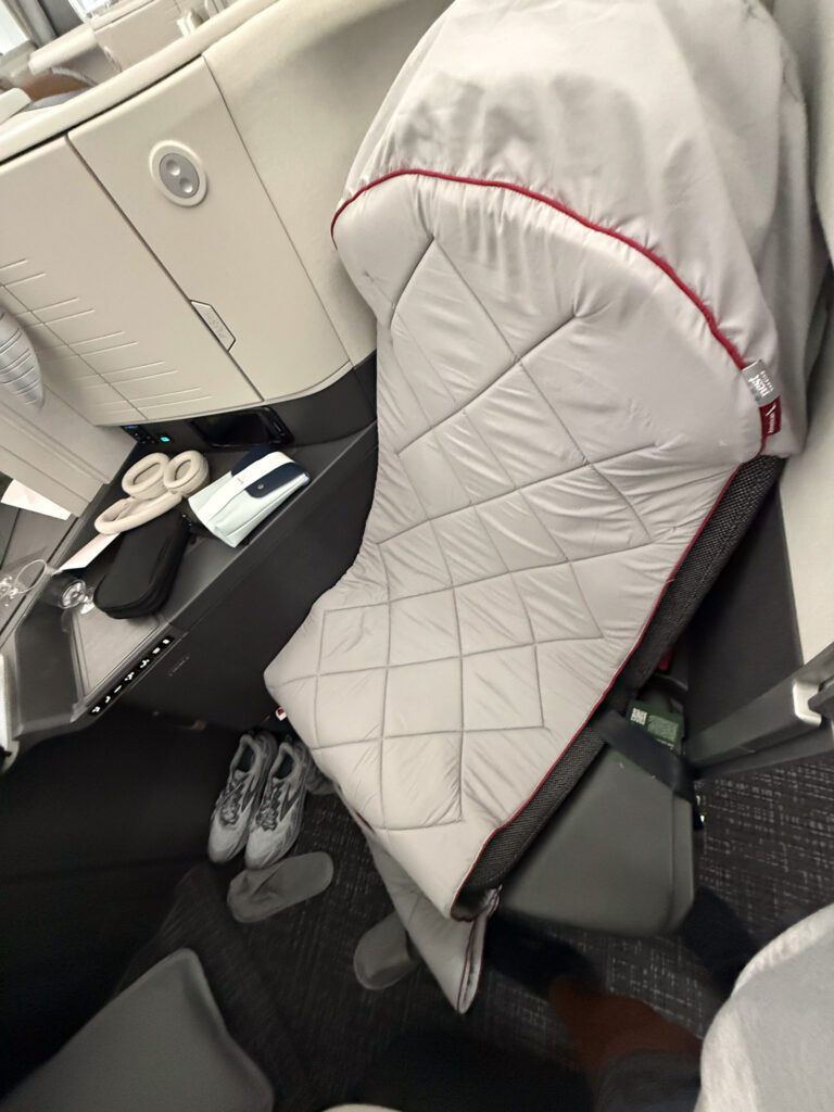 American Airlines 787-9 business class seat with mattress pad and bedding setup