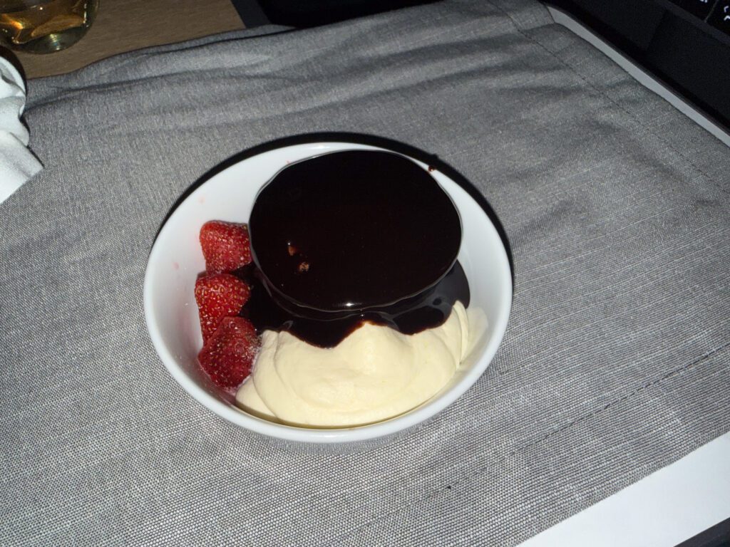 American Airlines business class dessert with ice cream, chocolate sauce, and strawberries