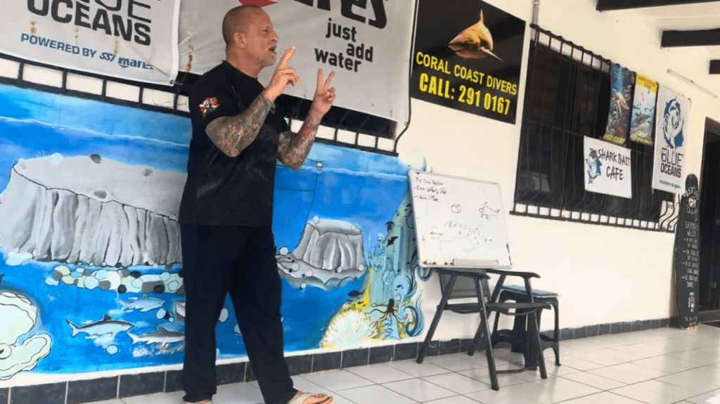 Owner of Coral Coast Divers giving the pre-dive shark safety briefing before a Fiji bull shark diving excursion in Beqa Lagoon