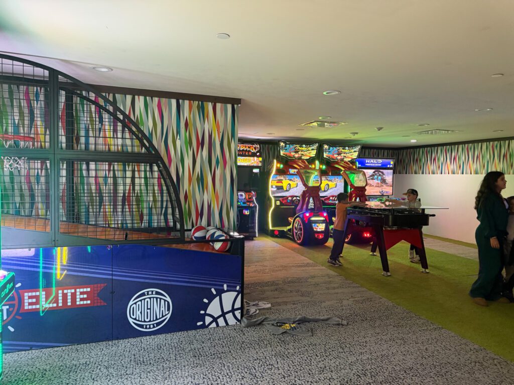Family game room at Grand Hyatt Vail with arcade games, basketball hoops, and entertainment area