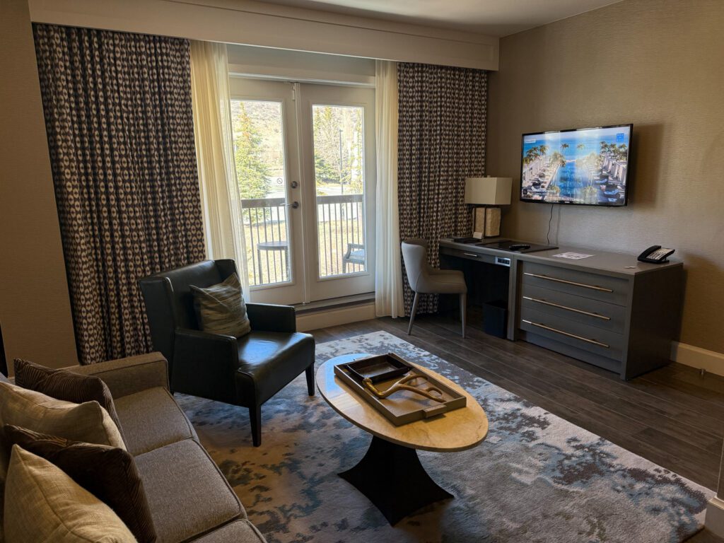 Living room in a Grand Suite at Grand Hyatt Vail featuring a balcony, workspace, sofa, and mountain resort views