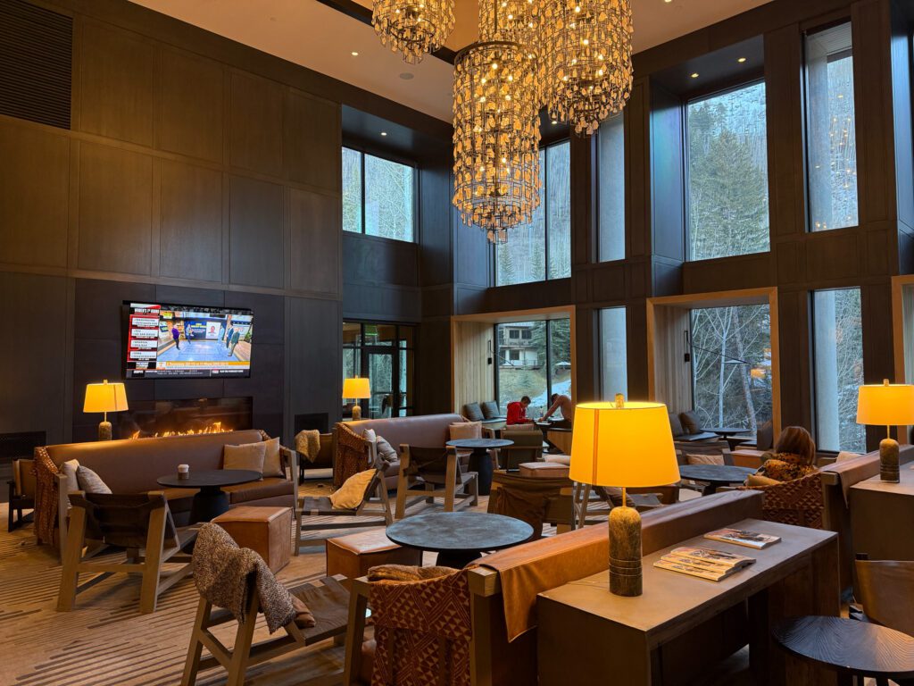 Grand Hyatt Vail lobby lounge with fireplace, floor-to-ceiling windows, and mountain-inspired luxury design