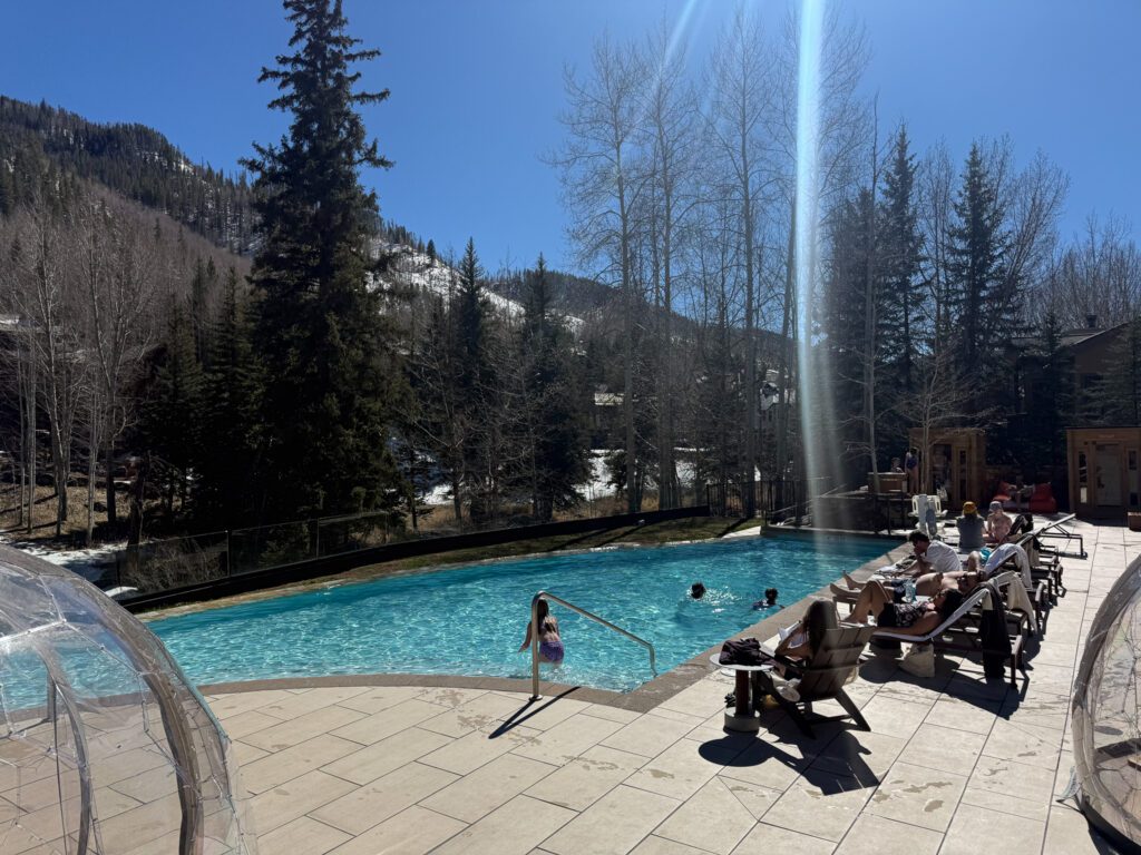 Outdoor heated pool at Grand Hyatt Vail surrounded by mountain views and lounge chairs