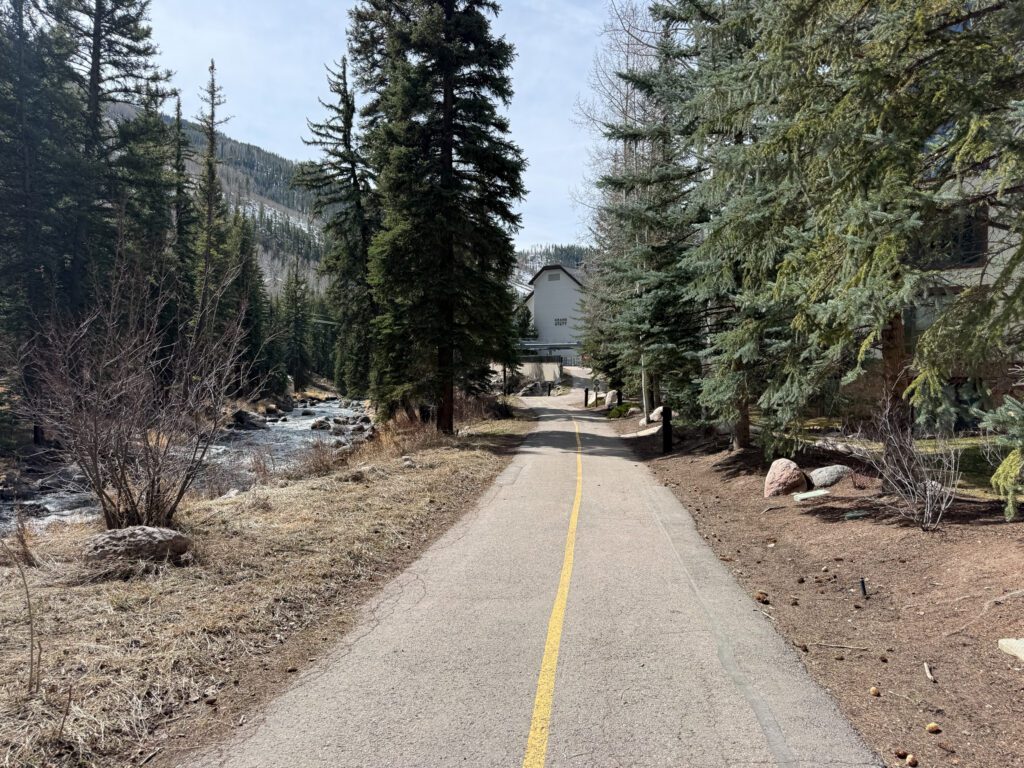 Paved walking and biking path along Gore Creek near Grand Hyatt Vail with mountain scenery