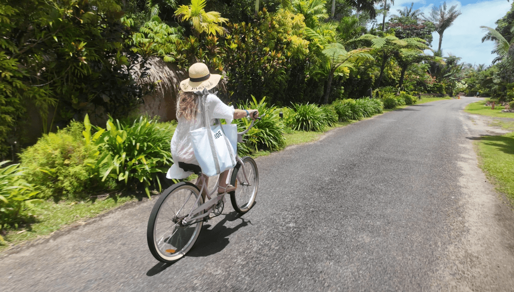 Guest riding a bicycle through the lush tropical grounds at Nanuku Resort Fiji