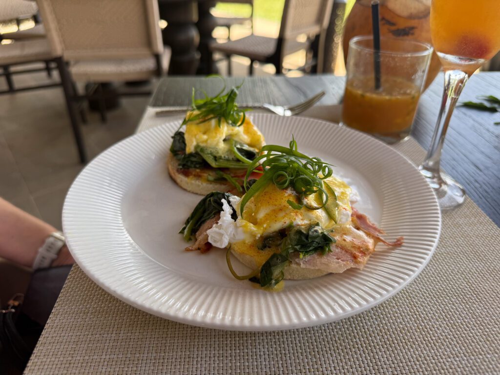 Eggs benedict breakfast at Nanuku Resort Fiji with tropical cocktails and oceanfront dining