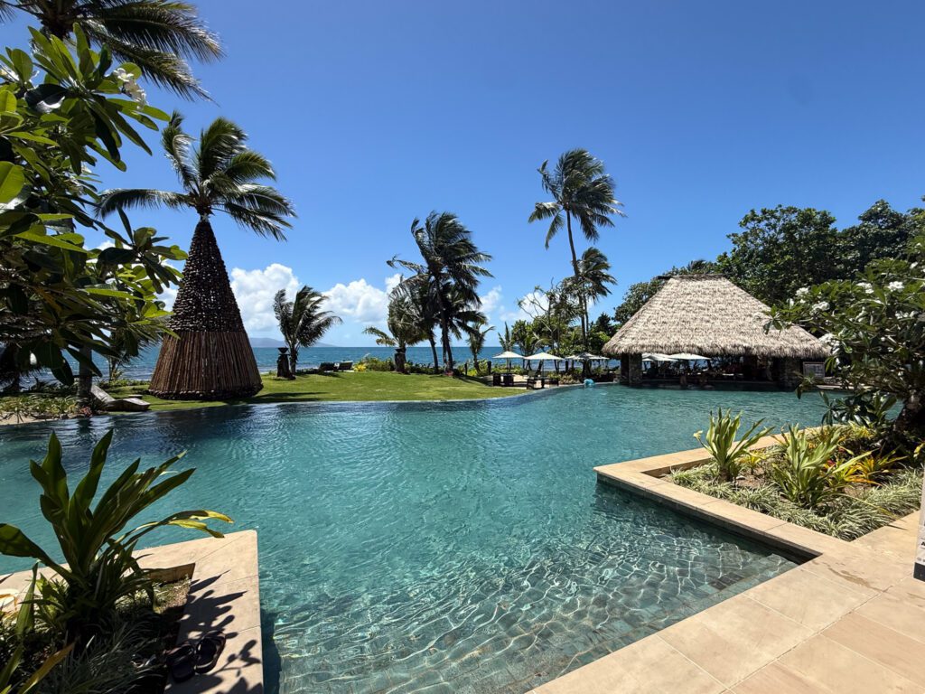 Oceanfront infinity pool at Nanuku Resort Fiji with palm trees and South Pacific views