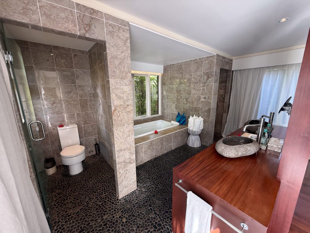 Large stone bathroom with soaking tub inside Nanuku Resort Fiji luxury villa