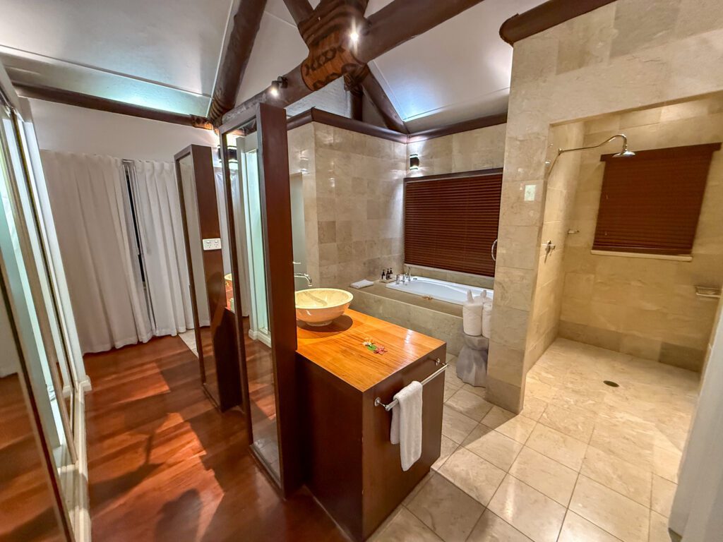 Luxury bathroom inside standard room villa at Nanuku Resort Fiji with soaking tub and rainfall shower