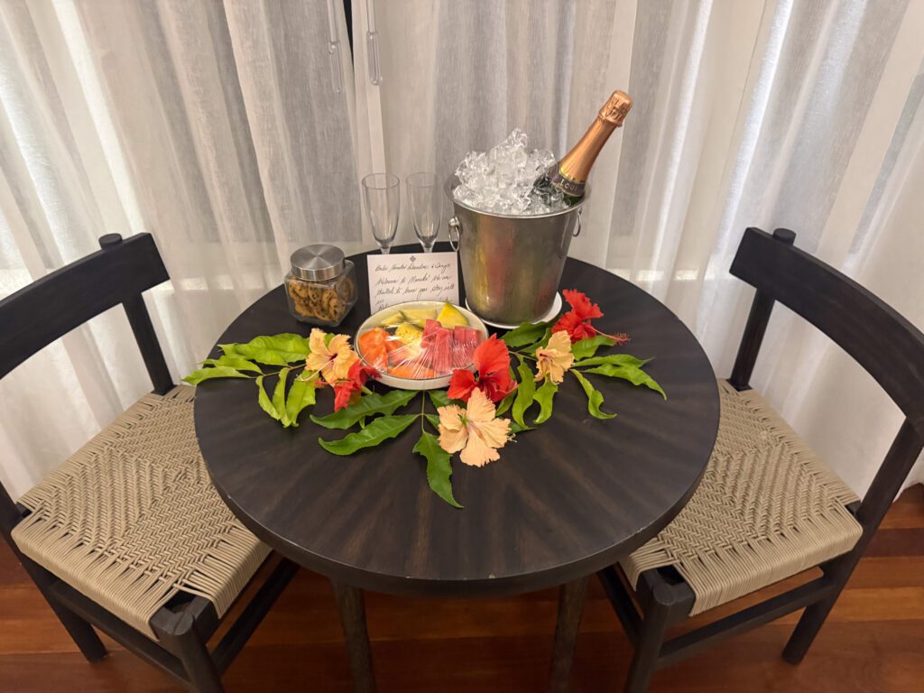 Champagne, fresh fruit, and tropical welcome amenity setup inside Nanuku Resort Fiji villa