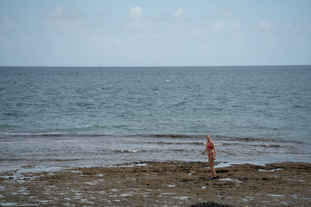 Guest exploring rocky tide pools along the shoreline at Nanuku Resort Fiji during low tide