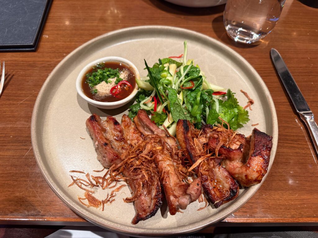 Grilled pork belly with fresh herb salad served at Onemata restaurant in Park Hyatt Auckland