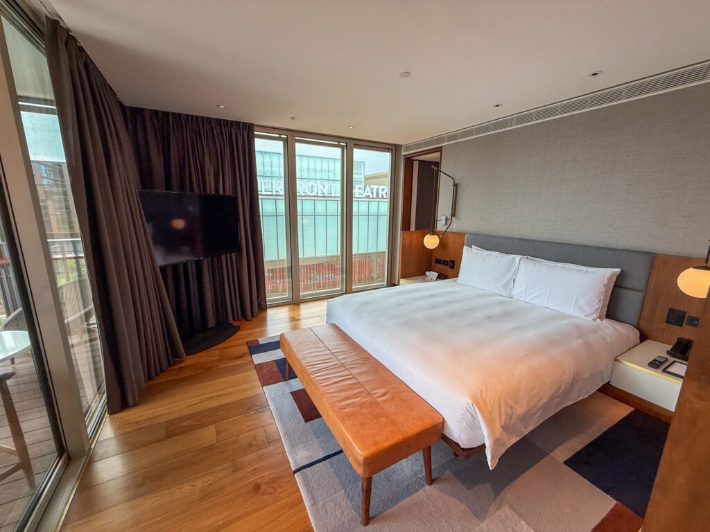 King bedroom in the Park Suite at Park Hyatt Auckland with floor-to-ceiling windows, balcony access, and modern waterfront design