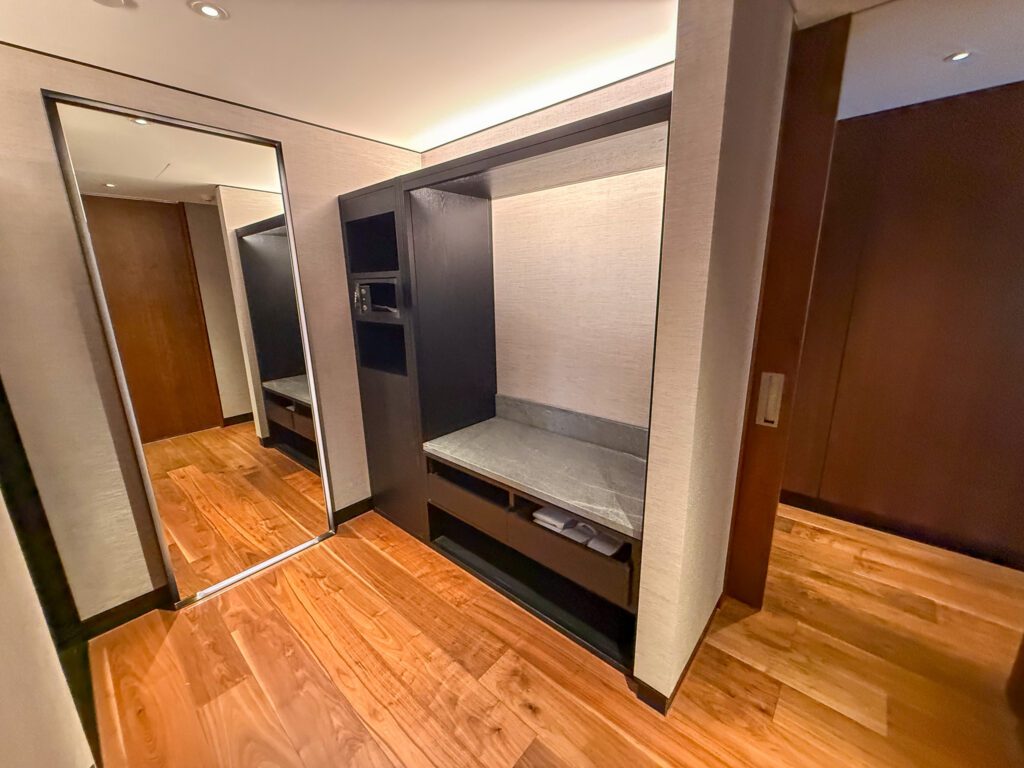 Entryway and dressing area in the Park Suite at Park Hyatt Auckland with luggage storage, wardrobe space, and hardwood floors