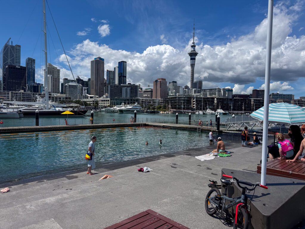 Wynyard Quarter waterfront in Auckland with the Sky Tower, marina, and public swimming area near Park Hyatt Auckland